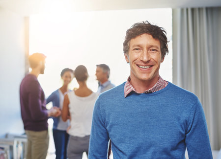 Feeling good about his career. Portrait of a businessman with his colleagues standing in the...
