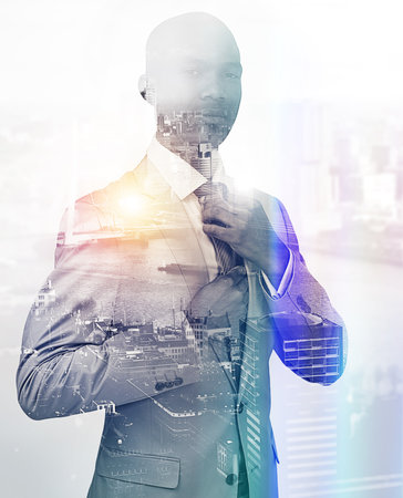 Ready to take this city by storm. Portrait of a handsome businessman superimposed over a cityscape.の写真素材