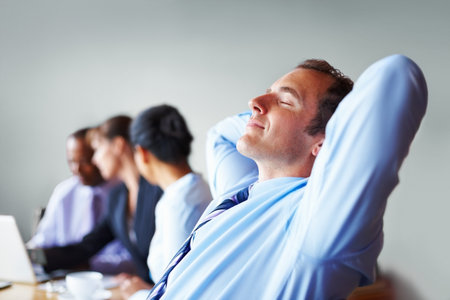 Executive taking break. Executive relaxing in chair with hands on back of head.の写真素材