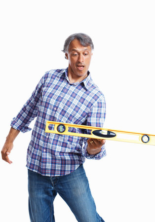 Mature architect balancing tool. Playful mature architect balancing spirit-level over white...