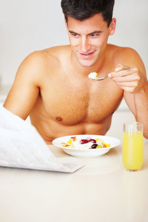 Building the perfect body with a healthy breakfast. a muscular man eating breakfast.の写真素材