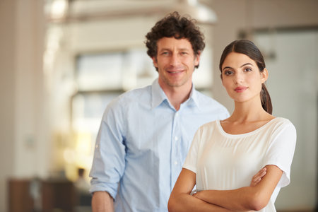 Leaders dont make excuses, they create results. Portrait of two coworkers standing in an office.の写真素材