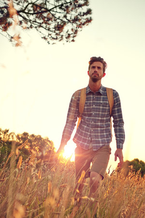 He prefers it outside. a handsome young man enjoying a hike.の写真素材