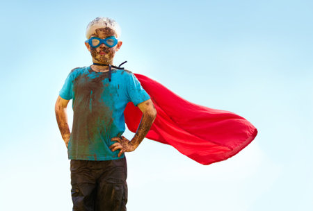 A muddy superhero. A little boy dressed as a superhero and covered in mud.の写真素材