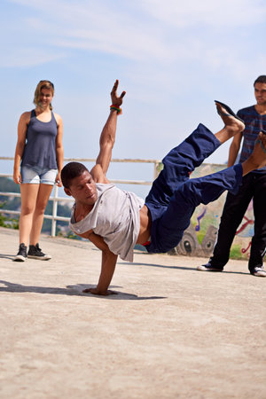 Street entertainment. a group of young people watching a breakdancer in the streets.