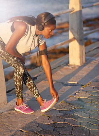 So ready for this run. a young woman stretching her legs while out for a run.