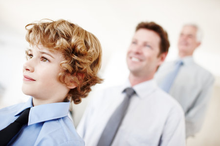 Going through the generations. a young boy standing with his father and grandfather.の写真素材