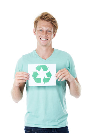 Taking responsibility for our waste. A happy young red-headed man holding up a recycling sign - portrait.の写真素材