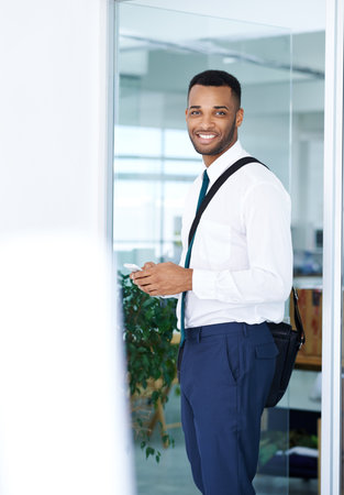Checking his texts in the office. A handsome young african american businessman using his smartphone...