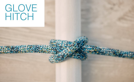 Above of hiking rope tied in a knot against a wooden background in studio. Glove hitch knot in a...
