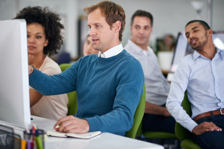 Pointing out what works and what doesnt. a group of creative businesspeople working together on a...
