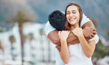Love, hug and couple in happy relationship outdoor with city bokeh for holiday, vacation or weekend outing. Care, affection and carefree man embrace woman or people with happiness togetherの写真素材