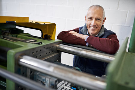 If you need something fixed, Im your man. Portrait of a mature man standing next to machinery in a...