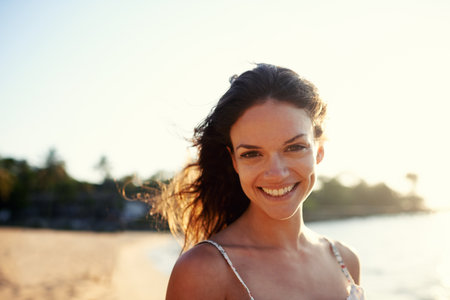 My happy place. Portrait of a beautiful young woman on the beach.の写真素材