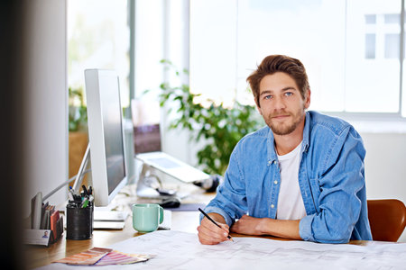 Modern technology is the creator of new jobs. a handsome young designer in his office.