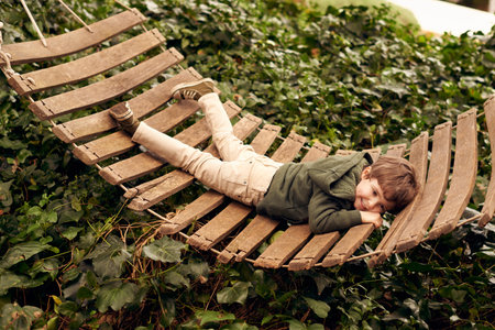 Aaah...the carefree days of childhood....A little boy relaxing in a hammock in his backyard.の写真素材