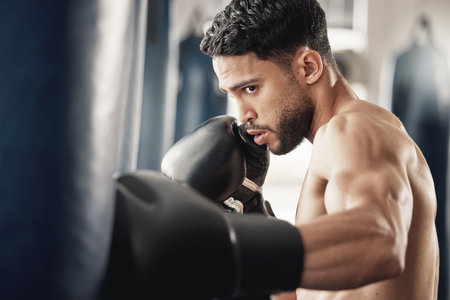 Training, fitness and workout man boxing punching bag for health, wellness and cardio exercise in...
