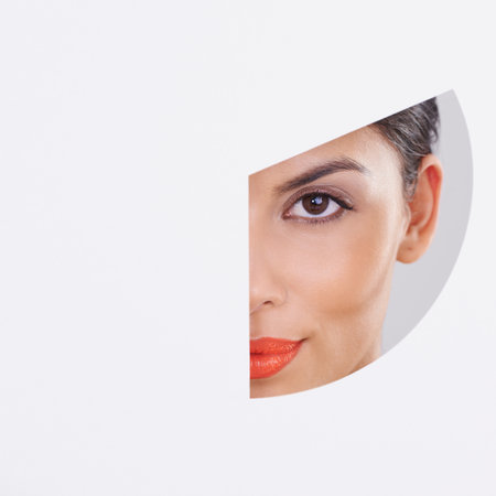 Look at those cheekbones. a beautiful young woman through a cut out shape.の写真素材