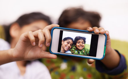Childhood snapshots. two siblings taking a photo of themselves at home.
