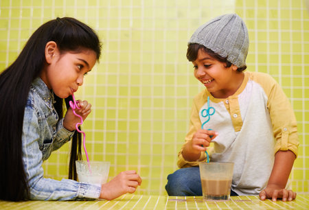 Its all about the slurp. a cute brother and sister drinking milkshakes with straws.