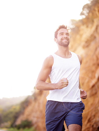 Perfect jogging weather. a handsome young man jogging outdoors.