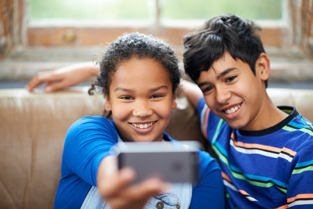 Taking a brother-sister selfie. a little brother and sister taking a selfie.