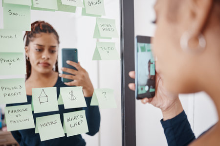 Woman entrepreneur with mirror selfie and sticky note for business planning with a sad, confused...