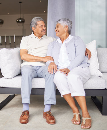 Retirement, love and marriage with senior couple sitting on sofa together for care, support and wellness. Elderly, trust and embrace with old age married man and woman in family homeの写真素材