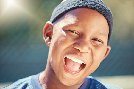 Fitness, a smile on face and a black child on basketball court in summer. Game, sport and happy healthy kid outside on school sports ground. Exercise, wellness and fun, boy playing in the sun in parkの写真素材