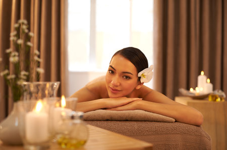 A girl could get used to this. A beautiful young woman relaxing on a massage table before her massage.の写真素材