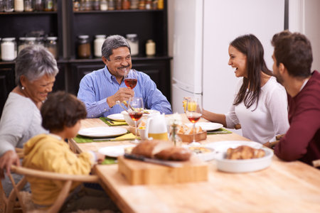 Cheers to the best family. A shot of a happy family sharing a meal together.の写真素材