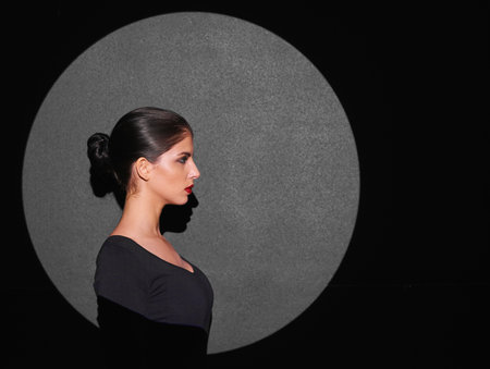 Youll circle around her beauty. A beautiful fashion model highlighted by a shaped portion of light.
