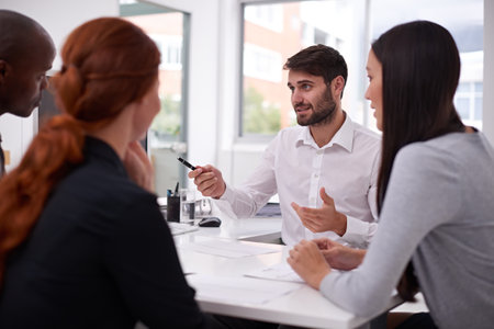 Explaining what he wants from the team. a diverse group of young businesspeople having a meeting in an office.の写真素材