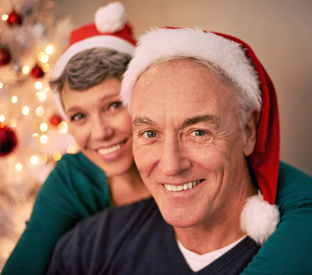 Celebrating Christmas. A cropped portrait of a happy mature couple in front of a Christmas tree.の写真素材