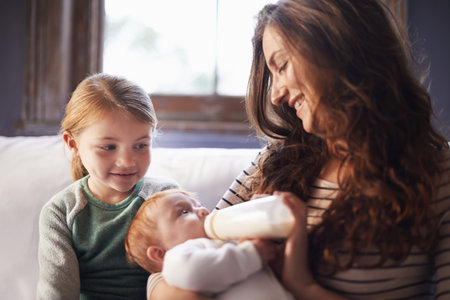 She loves her little sister. A shot of a family spending time together while mom nurses baby.の写真素材
