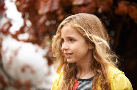 Another carefree day playing outside. a cute little girl playing outside on an Autumn day.の写真素材