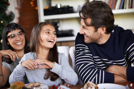 Oh dad you are so funny. a little girl laughing at christmas jokes.の写真素材