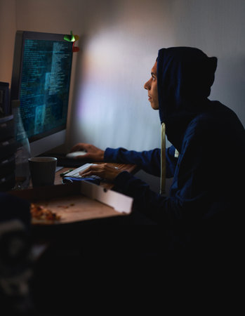 Working on a new game. a young programmer focused on his work.