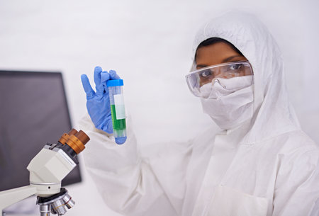 Guess what I have in here. A portrait of a young scientist in protective clothing holding up a test...