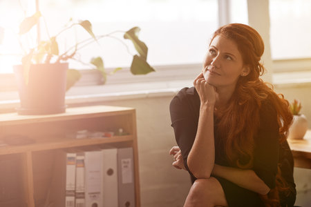 Dream big and work for your success. a young businesswoman sitting at her desk.の写真素材