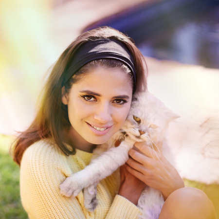 Showing my furry little friend some love. Portrait of a gorgeous young woman holding a cat.の写真素材