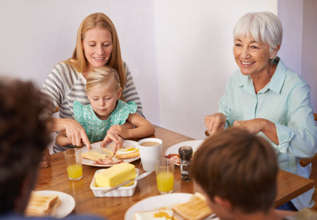 Moms an expert multitasker. A cropped shot of a happy multi-generation family having breakfast together at home.の写真素材