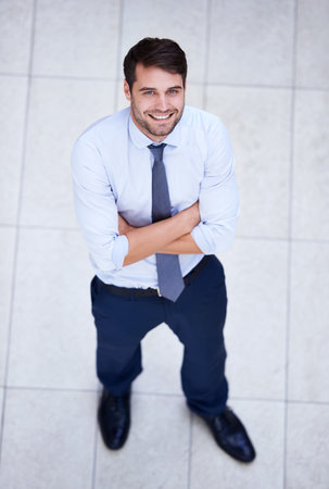 Setting his sights high. High angle portrait of a handsome and confident young businessman.の写真素材