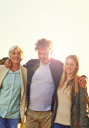 Time out with his two favorite women. a senior couple standing with their adult daughter.
