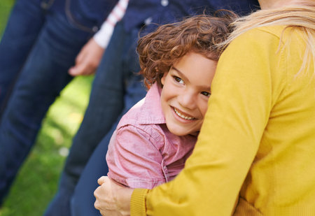 He loves his family. High angle shot of a young boy embracing his mother while standing outside.
