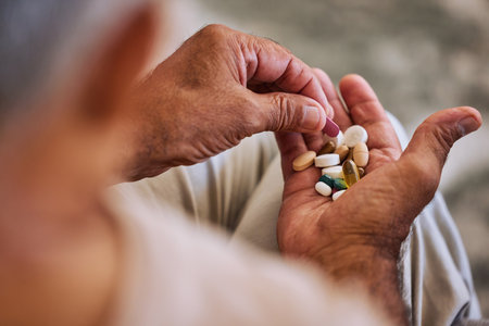 Pills, medicine and healthcare of senior man taking daily capsules for chronic illness, cancer or health. Wellness, medication and sick elderl with medical drugs, vitamins or supplements in his handの写真素材