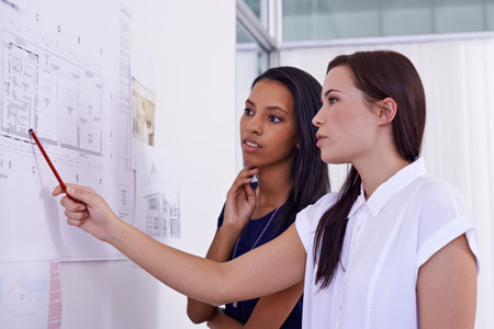 What if we changed this. two female architects examining building plans.の写真素材