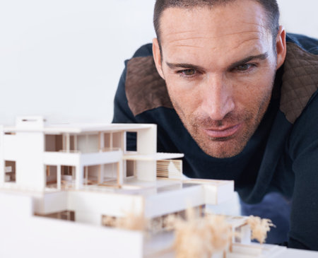 Making sure that every detail is perfect. Close-up of a male architect viewing a scale model.の写真素材