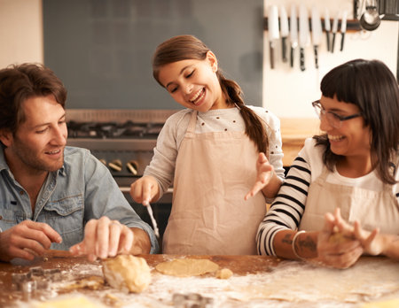 We should make some gingerbread women too. a family having fun baking in a kitchen.