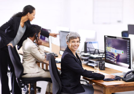 Hustle and bustle in a busy office. three businesswomen working in an office.の写真素材